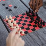 Real-Time Strategy Board Games - Unrecognizable multiracial male millennials playing chess at wooden table
