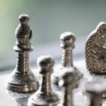 Economic Board Games - Metal chess pieces on board in room