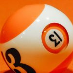Solo Board Games - Billiard ball with number on bright orange surface for complex intellectual board game