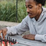 Cooperative Board Games - Focused black man making chess move