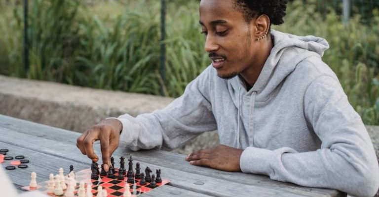 Cooperative Board Games - Focused black man making chess move