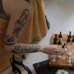 Board Game Events - Crop woman playing chess from couch