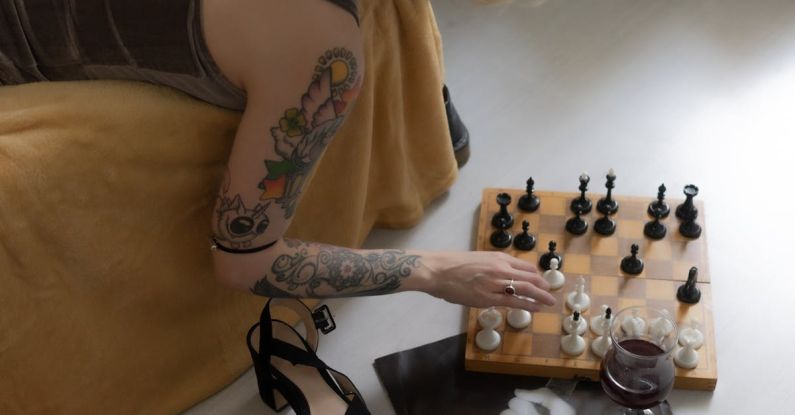 Board Game Events - Crop woman playing chess from couch