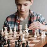 Board Game Convention - A Boy Playing a Game of Chess